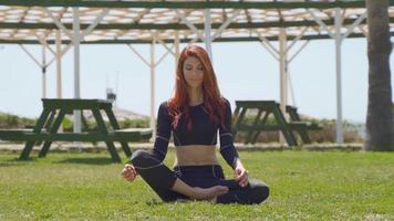 femme faisant du yoga au soleil. belle jeune femme faisant du yoga en vacances dans le jardin de l'hôtel, temps ensoleillé. video