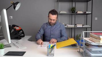 Document crumpling, office worker. The man working in his office crumples up the documents in his hand and throws them around when things don't go the way he wants. video