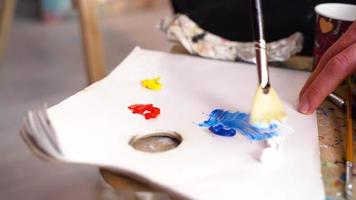 Painter mixing paint. Painter mixes colors on the palette. Sets the intermediate color. video