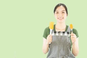 dama feliz sosteniendo cosas de cocina sobre el fondo del espacio de copia - gente concepto de preparación de comida hecha en casa foto