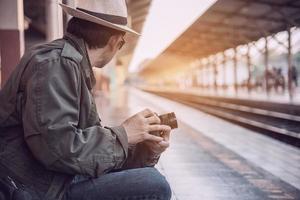 Travel man wait train at platform - people vacation lifestyle activities at train station transportation concept photo