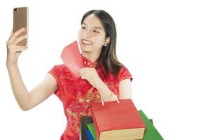 Happy Asian lady shopping in Chinese suite isolated over white copy space - woman day concept photo