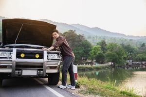 Man try to fix a car engine problem on a local road Chiang mai Thailand - people with car problem transportation concept photo