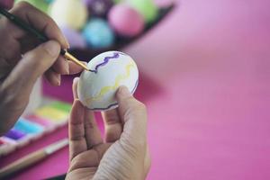 gente pintando coloridos huevos de pascua - concepto de celebración de vacaciones de pascua foto
