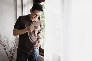 Relax Asian man drink coffee and read book in a modern style coffee shop - people with coffee cup easy lifestyle concept photo