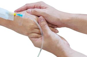 hombre sosteniendo a una mujer, paciente, mano con un tubo de inyección de medicina en una cama en un hospital foto