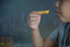 niño comiendo patatas fritas con salsa bañada en una mesa de madera blanca foto