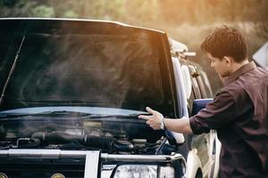 Man try to fix a car engine problem on a local road Chiang mai Thailand - people with car problem transportation concept photo