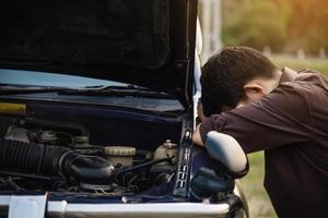 Man try to fix a car engine problem on a local road Chiang mai Thailand - people with car problem transportation concept photo