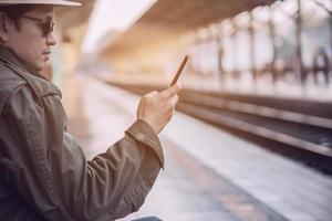 Travel man wait train at platform - people vacation lifestyle activities at train station transportation concept photo