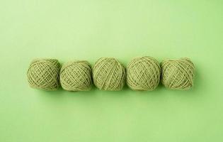bright green yarn wool in a raw on bright background, top view flat lay photo