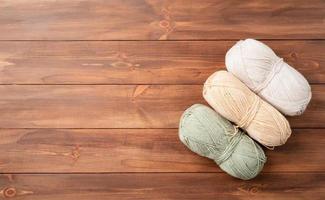 pastel colored yarn wool on wooden background photo