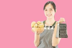 dama feliz sosteniendo cosas de cocina sobre el fondo del espacio de copia - gente concepto de preparación de comida hecha en casa foto