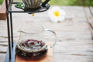 Man making drip fresh coffee in vintage coffee shop with green nature background - people with fresh coffee in nature concept photo