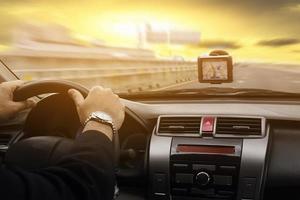 Business man is driving a car using GPS over warm sky yellow background photo