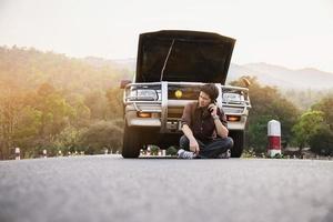 Man try to fix a car engine problem on a local road Chiang mai Thailand - people with car problem transportation concept photo