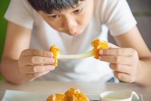 Boy ready to eat sticky stretch fried cheese ball - people and delicious cheese food concept photo