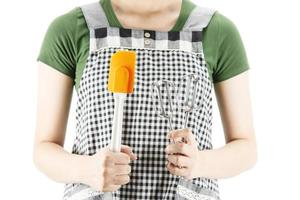 dama feliz sosteniendo cosas de cocina sobre el fondo del espacio de copia - gente concepto de preparación de comida hecha en casa foto