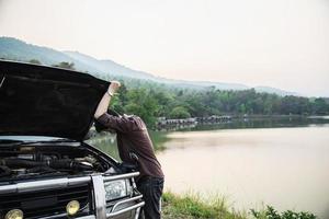 Man try to fix a car engine problem on a local road Chiang mai Thailand - people with car problem transportation concept photo