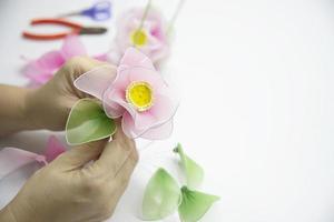mujer haciendo una hermosa flor de nailon - gente con concepto de flor hecha a mano diy foto