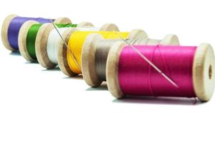 Isolated wooden spools of thread with a needle photo