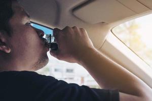 el hombre que toma una bebida saludable mientras conduce se preocupa por un refresco despierto y una conducción robusta: conduzca de forma segura con algún concepto de bebida refrescante foto