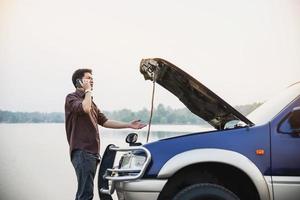 Man try to fix a car engine problem on a local road Chiang mai Thailand - people with car problem transportation concept photo