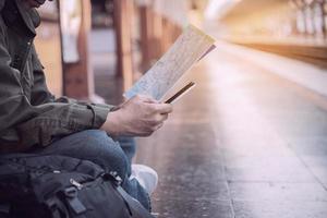 hombre de viaje espera el tren en la plataforma - personas actividades de estilo de vida de vacaciones en el concepto de transporte de la estación de tren foto