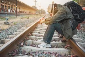 hombre de viaje espera el tren en la plataforma - personas actividades de estilo de vida de vacaciones en el concepto de transporte de la estación de tren foto