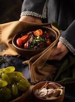 A vertical shot of a chef serving a gourmet salad dish photo