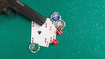 A top shot of a weapon next to some playing cards and dice on a poker board. photo