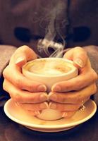 Woman hands hold a cup of coffee. Vertical image. Vintage style. photo