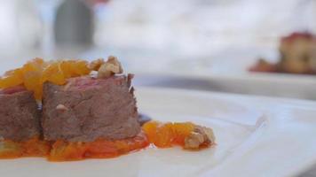 Grilled meat with sauce.Red meat garnished with walnuts and dried apricots. video