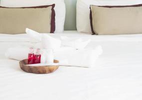Hotel towel set with toothbrush and toothpaste on white bed photo