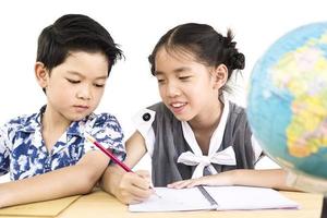 Asian kids are studying the globe over white background photo