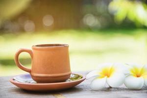 taza de café en el fondo del jardín verde - café con concepto de fondo de la naturaleza foto