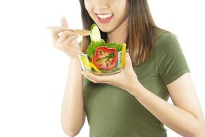 Happy lady enjoy eating vegetable salad over white copy space background - people with organic healthy food concept photo