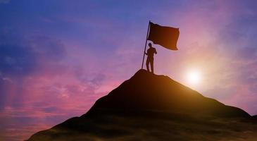 hombre de negocios con bandera en la cima de la montaña. éxito, logro de objetivos, liderazgo y concepto de logro empresarial foto