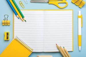 Top view of blank notepad open and school supplies with space for text. Back to school concept photo