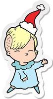 sticker cartoon of a squinting girl wearing santa hat vector