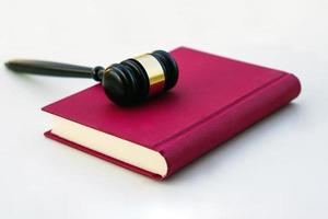 Close up of judge gavel, lawyer, law, justice placed on law book on white background. photo