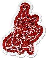 friendly cartoon distressed sticker of a fox wearing santa hat vector