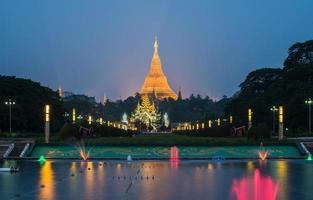 The Shwedagon pagoda with the colourful fountain view from people's park in Yangon township of Myanmar at night. photo