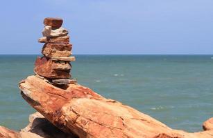 Pebble stone pyramid against blue sea photo