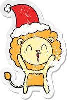 laughing lion distressed sticker cartoon of a wearing santa hat vector