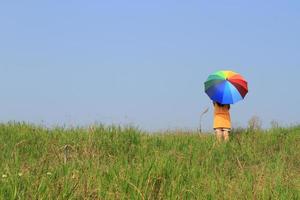Beautiful woman holding multicolored umbrella and blue sky photo