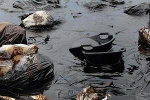 Water pollution - old garbage and oil photo