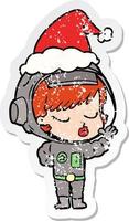 distressed sticker cartoon of a pretty astronaut girl wearing santa hat vector