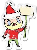 distressed sticker cartoon of a bearded protester crying wearing santa hat vector