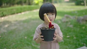 um filho da família leva restos de frutas e legumes para aprender a fazer adubo natural. no jardim da frente nos feriados